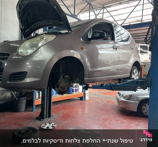 רכב על ליפט במוסך עם גלגל מפורק